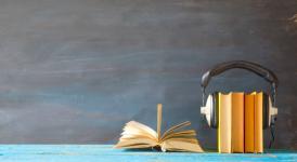 audio-book-concept-with-stack-of-books-headphones-smartphone-and-cup-of-coffee-panorama-good.jpg