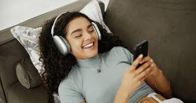 cellphone-relax-and-woman-with-headphones-on-sofa-listening-to-audiobook-with-mobile-app-for.jpg