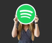woman-holding-up-spotify-icon-isolated.webp